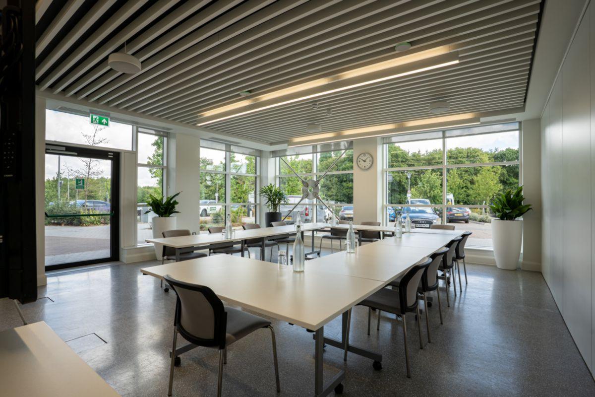 empty meeting room setup with tables and chairs in a rectangle formation