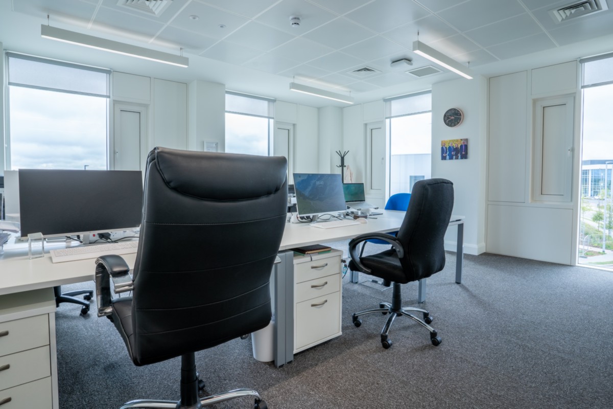 A shared office with computers and chairs in the Plaza
